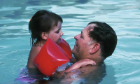 Girl in the pool with her father